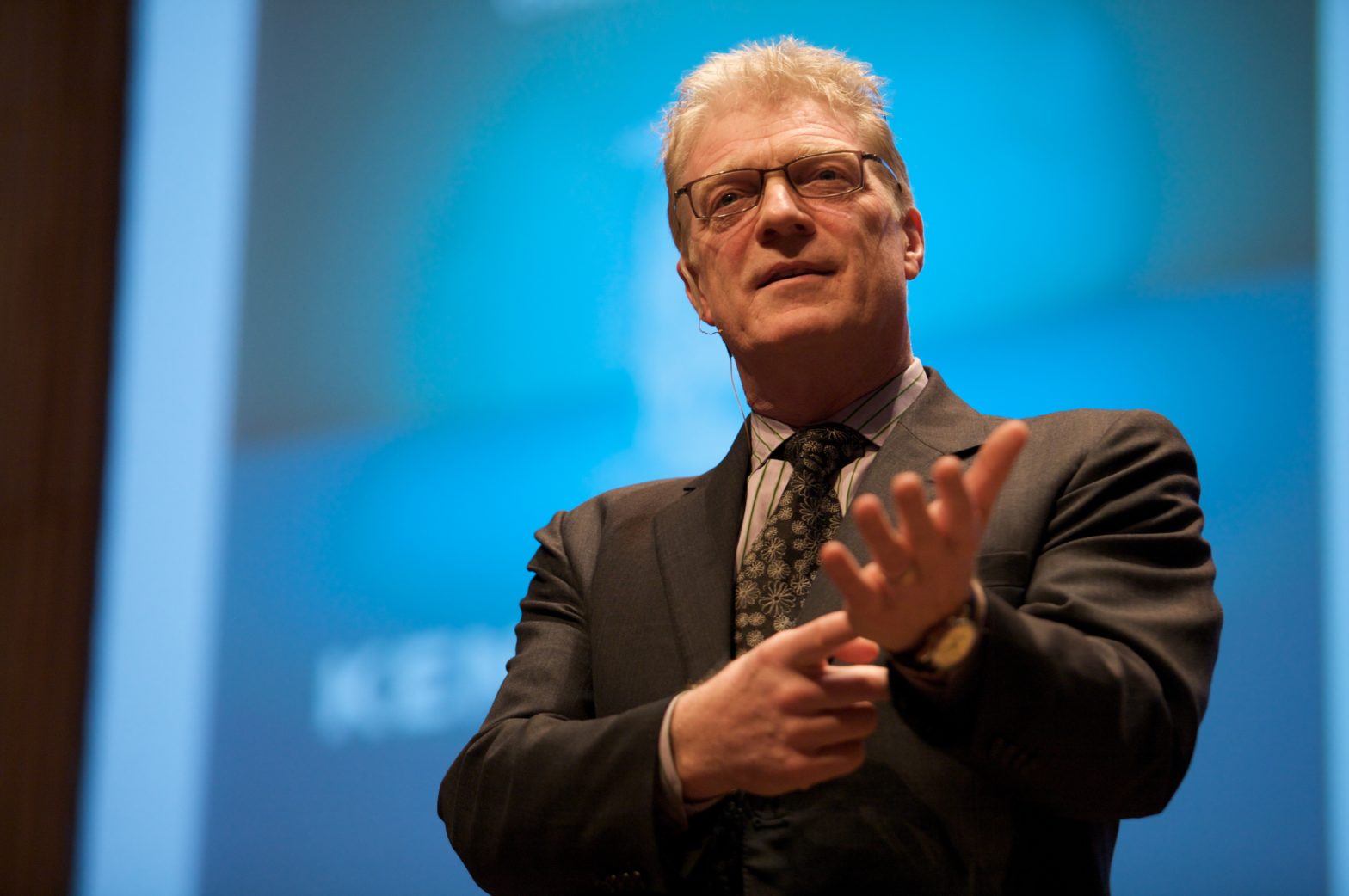 Image of Sir Ken Robinson Speaking at a conference; visible from the torso up